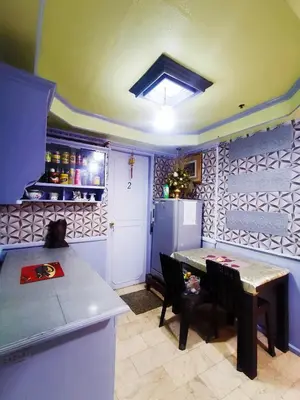 a kitchen with a table and a refrigerator at Cubao Quezon city Transient condo unit in Manila