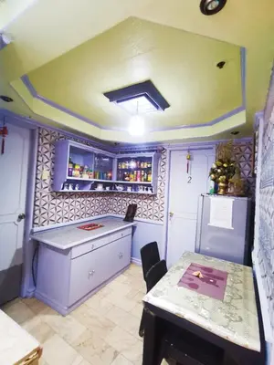 a kitchen with a counter and a table and a refrigerator at Cubao Quezon city Transient condo unit in Manila