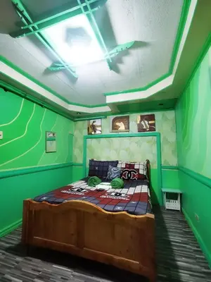 a bedroom with a bed with green walls at Cubao Quezon city Transient condo unit in Manila