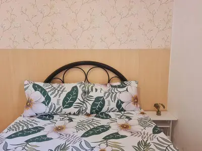 a bed with two pillows and a floral headboard at Muji-inspired Home, 2-BR Bungalow Home Trece Martires in Trece Martires