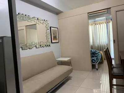 a living room with a couch and a mirror at Wind and Sea at Sea Residences in Manila