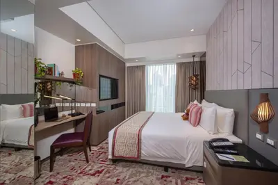 a hotel room with a bed and a desk and a bedroom at Somerset Central Salcedo Makati in Manila