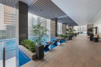 an office lobby with a pool and plants at Somerset Central Salcedo Makati in Manila