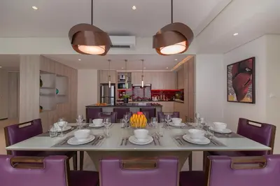 a dining room with a large table and purple chairs at Somerset Central Salcedo Makati in Manila