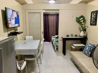 a living room with a couch and a table at Sea Residences by JH & LD's Condotel in Manila