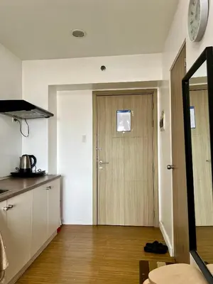 a kitchen with a wooden door in a room at Taguig City Grace Residences with small balcony in Manila