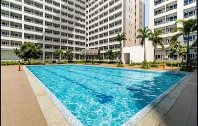 a large swimming pool in front of a building at Taguig City Grace Residences with small balcony in Manila