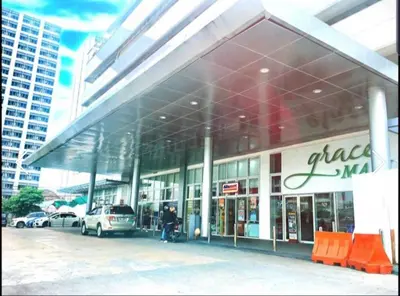a large building with cars parked in front of it at Taguig City Grace Residences with small balcony in Manila