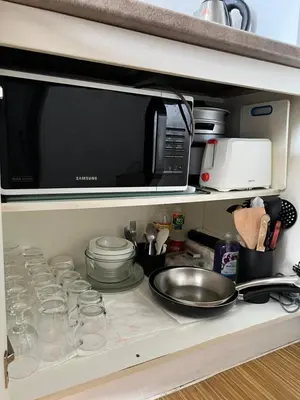 a kitchen counter with a microwave and some dishes at Taguig City Grace Residences with small balcony in Manila