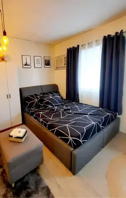 a bedroom with a bed with a black bedspread at Amaia Steps Nuvali fully furnished unit with swimming pool view near Carmelray Pitland in Calamba
