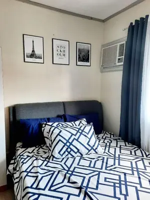 a bedroom with a bed with a blue and white comforter at Amaia Steps Nuvali fully furnished unit with swimming pool view near Carmelray Pitland in Calamba