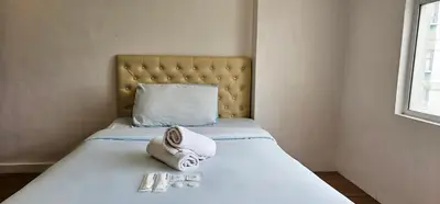 a hotel room with a bed with a towel on it at Gilmore Tower Suites By SMS Hospitality in Quezon City