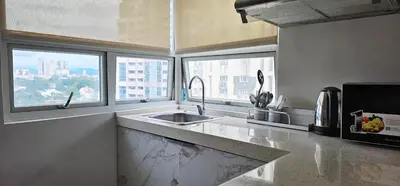a kitchen with a sink and two windows in it at Gilmore Tower Suites By SMS Hospitality in Quezon City