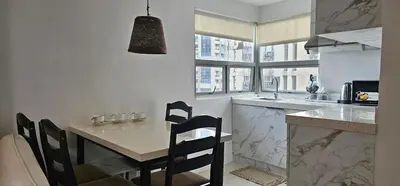 a kitchen with a counter and a table with chairs at Gilmore Tower Suites By SMS Hospitality in Quezon City