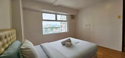 a room with a bed and a window at Gilmore Tower Suites By SMS Hospitality in Quezon City