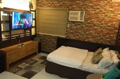 a bedroom with a bed and a tv on a brick wall at CENTROPOLIS 4, Fun & Playful in Manila