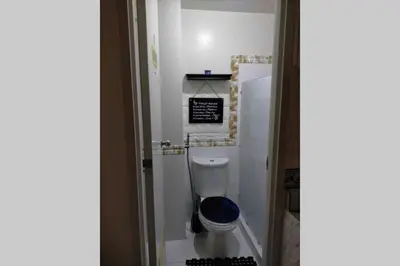 a bathroom with a toilet with a blue seat at CENTROPOLIS 4, Fun & Playful in Manila