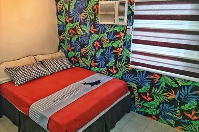 a small bed in a small room with a curtain at CENTROPOLIS 3, Tropical Modern in Manila