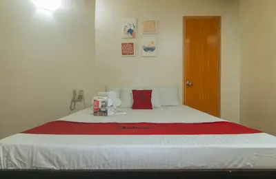 a bedroom with a bed with a red blanket on it at RedDoorz near EDSA Camp Crame in Manila