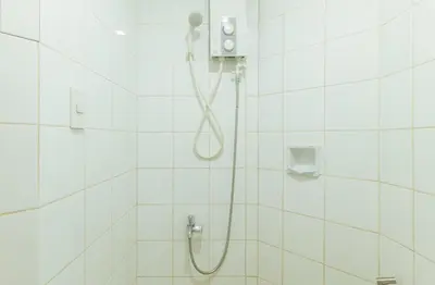 a white bathroom with a shower with a shower head at RedDoorz near EDSA Camp Crame in Manila