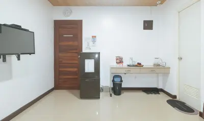 a room with a refrigerator and a desk and a tv at RedDoorz at RJs Bldg near Lyceum Gen Trias Cavite Cion Suites in General Trias