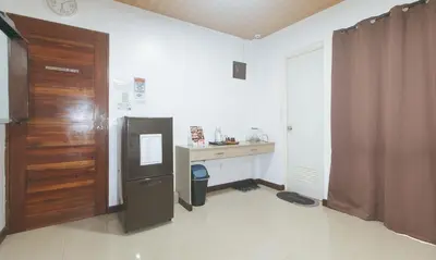 a kitchen with a refrigerator and a table and a door at RedDoorz at RJs Bldg near Lyceum Gen Trias Cavite Cion Suites in General Trias