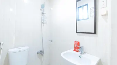 a bathroom with a toilet and a sink and a mirror at RedDoorz at RJs Bldg near Lyceum Gen Trias Cavite Cion Suites in General Trias