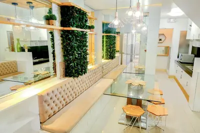 a restaurant with a bench and plants on the wall at House of Citiflora Unit A in Manila