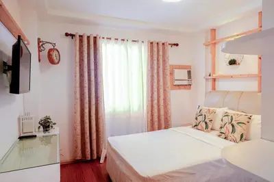 a small bedroom with a bed and a window at House of Citiflora Unit A in Manila