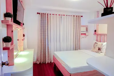 a small room with a bed and a window at House of Citiflora Unit A in Manila