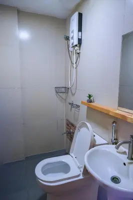a bathroom with a toilet and a sink and a shower at House of Citiflora Unit A in Manila