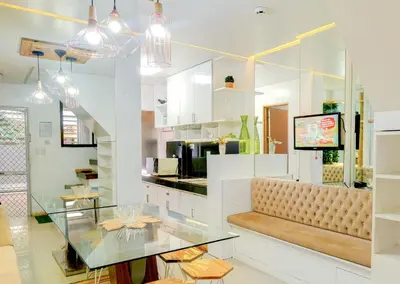 a dining room with a glass table and a bench at House of Citiflora Unit A in Manila
