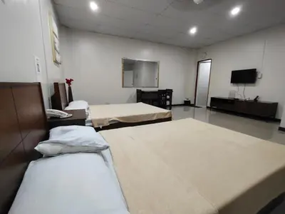 a room with three beds and a flat screen tv at La Belladoza near NAIA T1 Airport in Manila