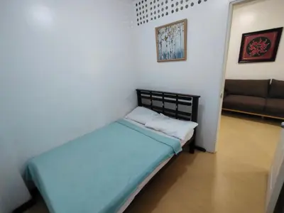 a small bedroom with a bed and a couch at La Belladoza near NAIA T1 Airport in Manila