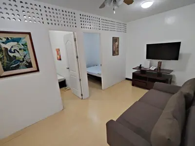 a living room with a couch and a flat screen tv at La Belladoza near NAIA T1 Airport in Manila