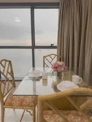 a dining room table with chairs and a table with flowers on it at Magnificent View of Manila Bay, Roxas Blvd, US Embassy in Manila