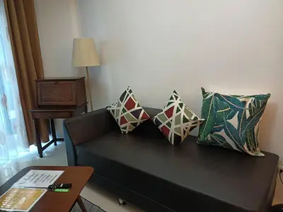 a living room with a black couch with pillows at Magnificent View of Manila Bay, Roxas Blvd, US Embassy in Manila