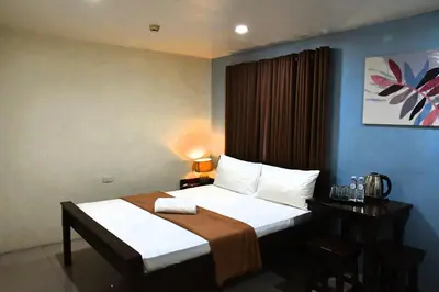 a hotel room with a bed and a desk with a bed sidx sidx at Arzo Hotel Makati in Manila