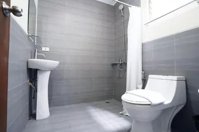 a bathroom with a white toilet and a sink at Arzo Hotel Makati in Manila