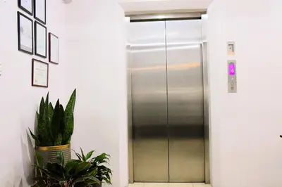 an elevator in an office with a potted plant at Arzo Hotel Makati in Manila