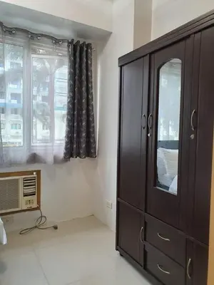 a bedroom with a dresser and a window at Vangie's Place at SEA RESIDENCES in Manila