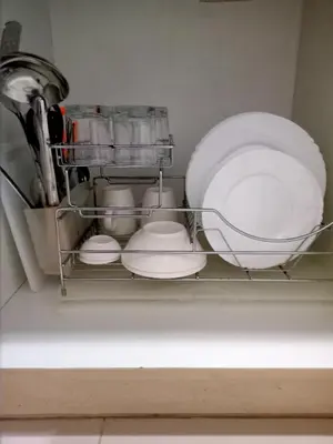 a shelf in a dishwasher with dishes and plates at Vangie's Place at SEA RESIDENCES in Manila