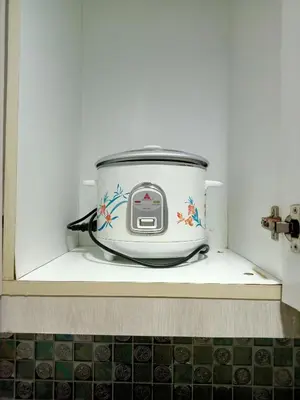 a slow cooker sitting on a shelf in a kitchen at Vangie's Place at SEA RESIDENCES in Manila
