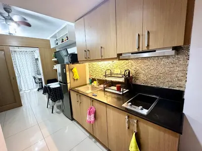 a kitchen with a sink and a refrigerator at Kathys Crib at Shell Residences in Manila