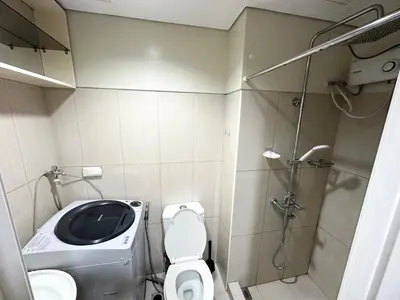 a small bathroom with a toilet and a shower at Kathys Crib at Shell Residences in Manila