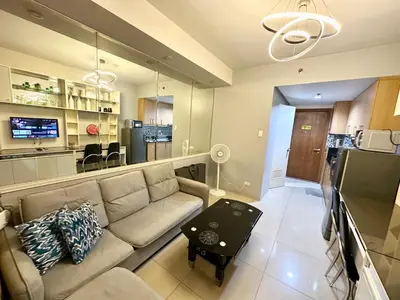 a living room with a couch and a table at Kathys Crib at Shell Residences in Manila