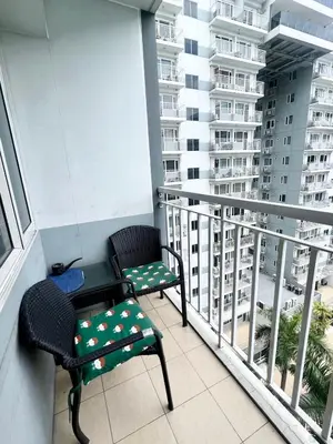 a balcony with two chairs and a table at Kathys Crib at Shell Residences in Manila