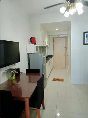 a kitchen with a dining table and a kitchen with a refrigerator at SEA RESIDENCES F in Manila