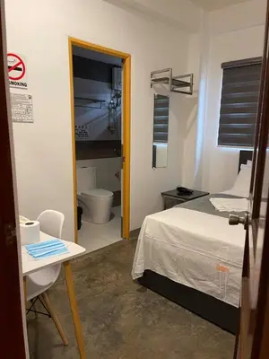 a bedroom with a bed and a bathroom with a toilet at 8 Zhensen Inn in Bacoor