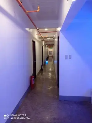 an empty hallway in a building with a blue light at 8 Zhensen Inn in Bacoor